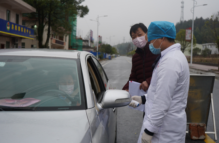 洛阳镇区疫情防控检查站值守人员冒雨为外来人员测量体温_WPS图片.jpg