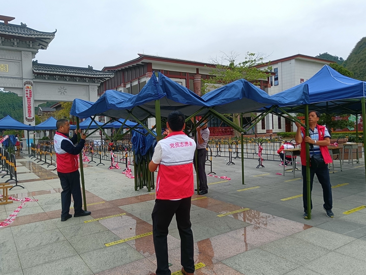 志愿者在核酸采集点布置场地.jpg