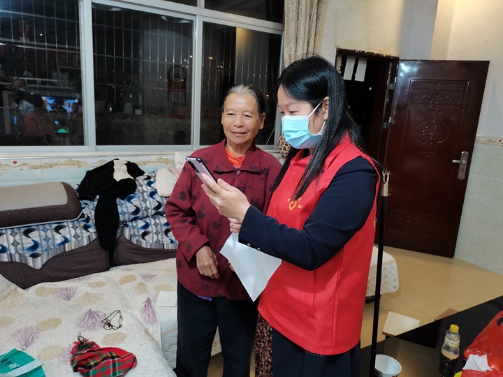 志愿者入户指导居民加入“团体码”.jpg