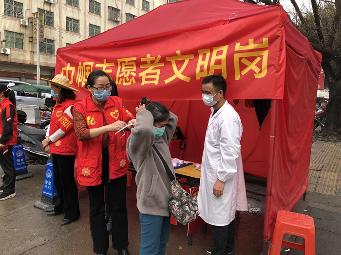 在巾帼志愿者文明岗为群众系上口罩.png