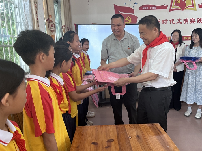 2.县政协主席林昌卫为游溪镇柳坑中心小学的学生发放书包.jpg