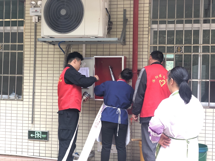 12月17日，敬老院工作人员在志愿者的指导下学习使用灭火带.jpg