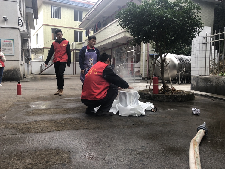 12月17日，敬老院工作人员在志愿者的指导下学习使用灭火罩.jpg