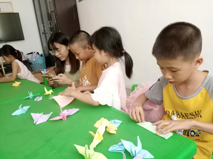 志愿者在课程上教孩子们折叠千纸鹤.png